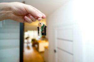 Holding house keys in front of the entrance.