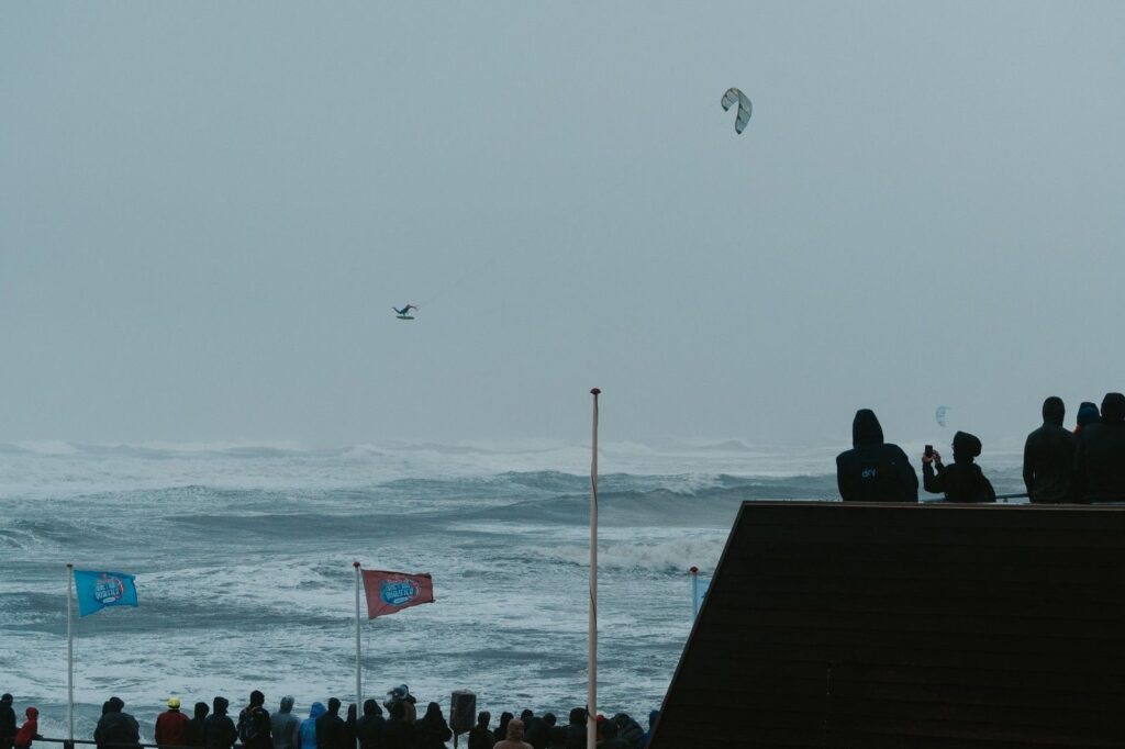 Kitesurfer high above the North Sea at Nørre Vorupør with spectators on the beach