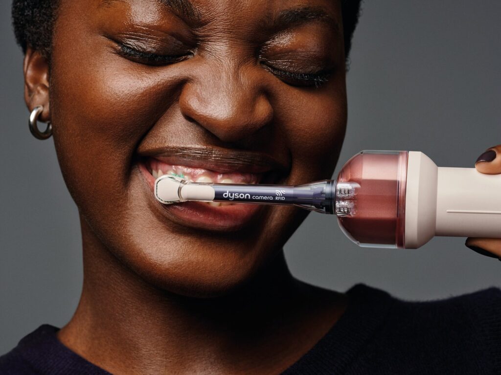 A person brushing with the Dyson CameraJet toothbrush